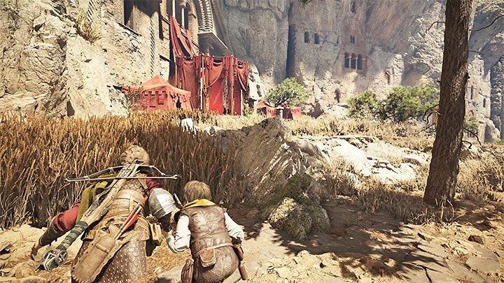 Jump down into the tall grass to the left of the main path and approach the red tent - Plague Tale Requiem: Chapter 9, Find a way around the checkpoint - walkthrough - Chapter 9 - Tales and Revelations - A Plague Tale Requiem Guide, Walkthrough