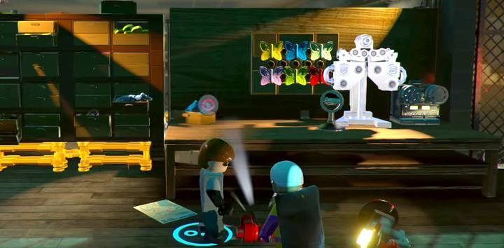 Once the stealth section is over, collect the crank from under the workshop and mount it on the machine located at the end of the room - Elastigirl On The Case - Level 4 in LEGO The Incredibles Walkthrough - Walkthrough - LEGO The Incredibles Game Guide