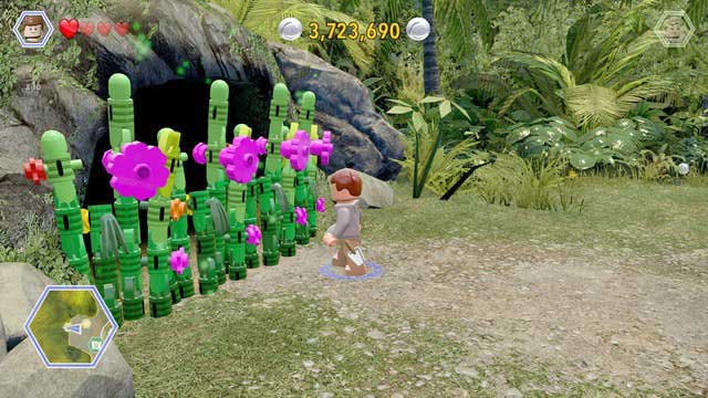 As Grant, walk to the plants blocking the access to the cave and cut them - Dilophosaurus Territory | Jurassic Park - secrets in free roam - Jurassic Park - secrets in free roam - LEGO Jurassic World Game Guide & Walkthrough