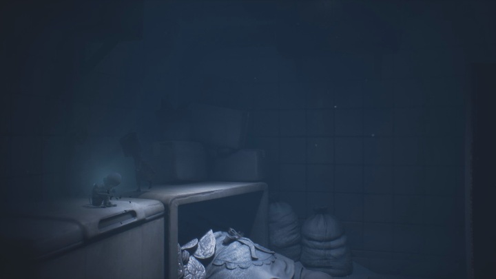The Glitching Remains lie on the tabletop - Little Nightmares 2: Glitching Remains in Chapter 2 Orphanage - list - Glitching Remains - Little Nightmares 2 Guide