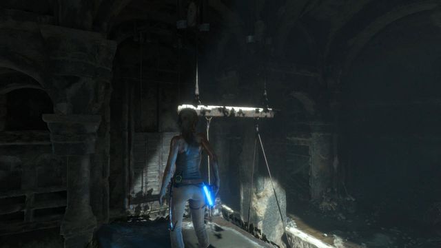Once you stand on the pillar, notice that above the counterweight a board partially painted in white is hanging - Rise of the Tomb Raider: Climb to the top of main chamber of tomb walkthrough - Syria - Lost tomb - Rise of the Tomb Raider Guide